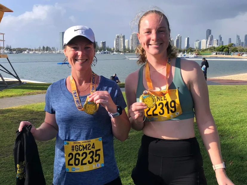 Two club members wearing finishers medals at a city fun run