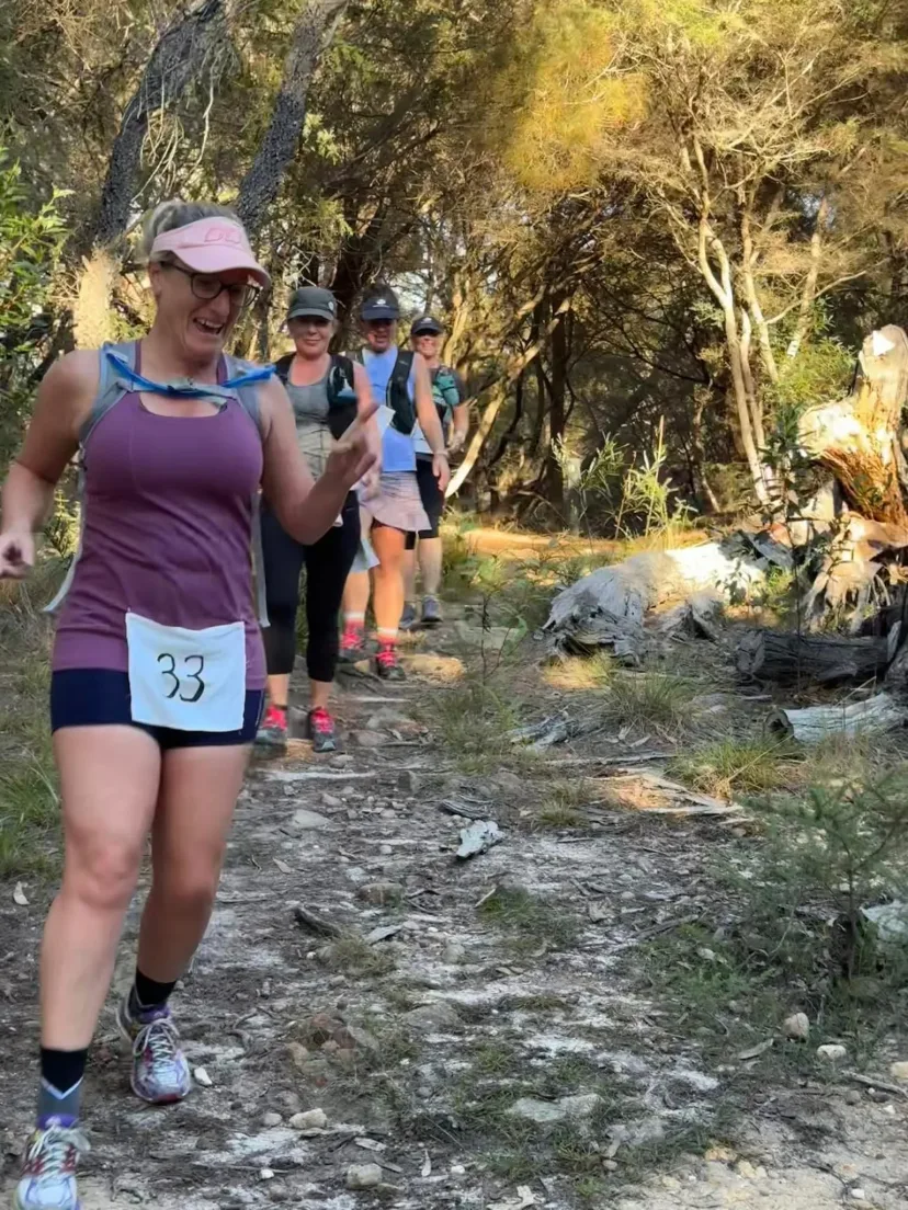 Runner in a race bib on a rocky coastal trail