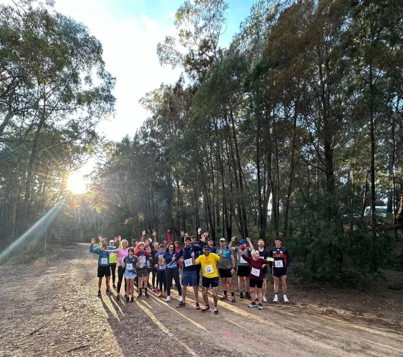 Runners lined up across a bush trail at sunrise