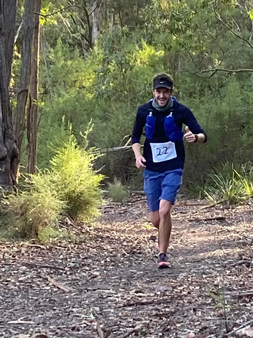 Runner on a trail through eucalypt forest