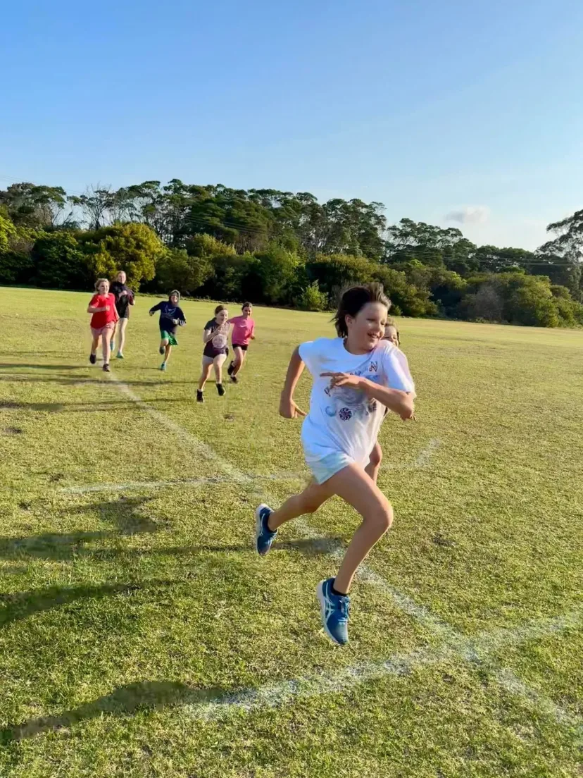 Young runner sprinting across the oval
