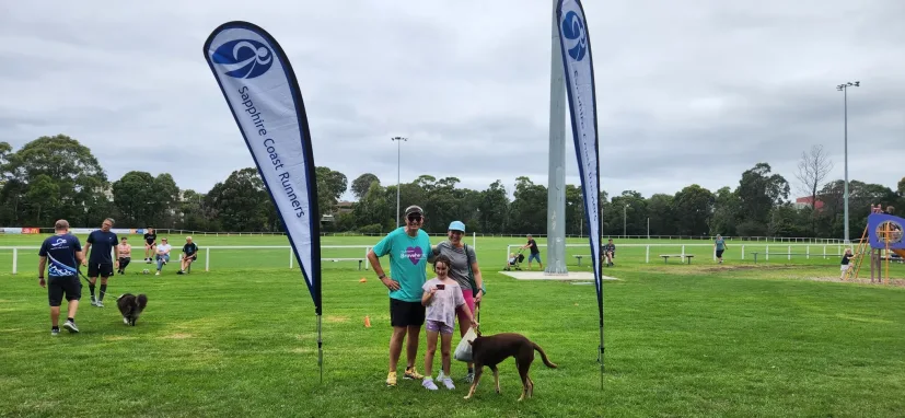 Junior session on the oval with club flags and a dog