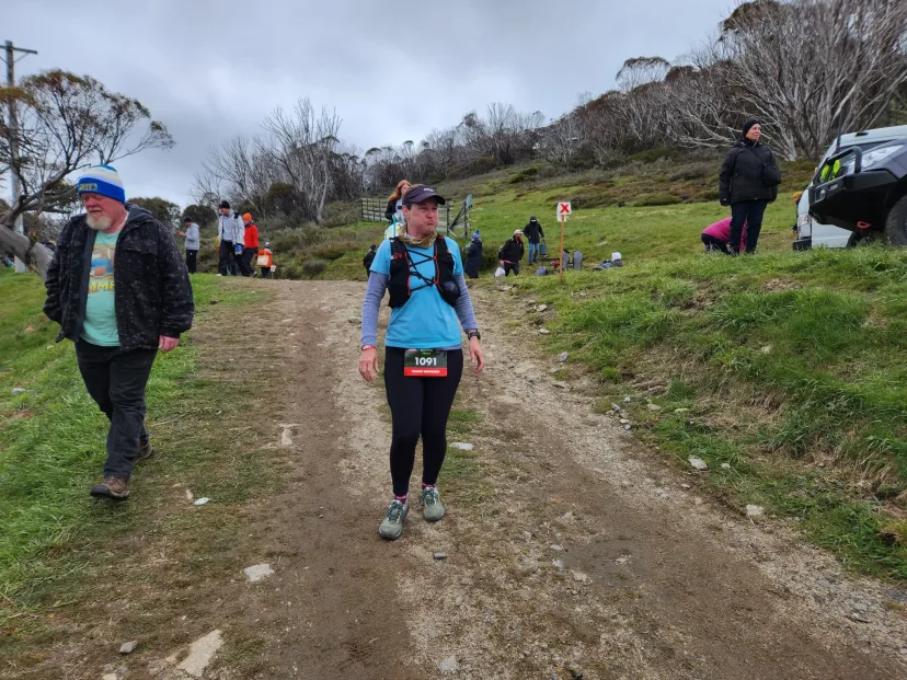 Runner coming up a dirt trail with others behind