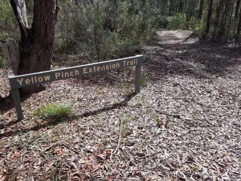 Sign for the Yellow Pinch Extension Trail beside the track