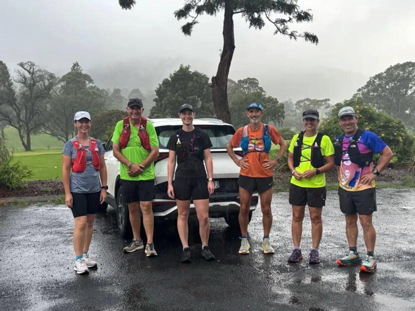 Club members crossing floodwater on a trail