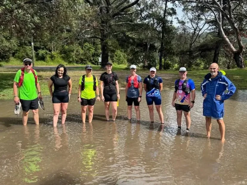 Club members crossing floodwater on a trail