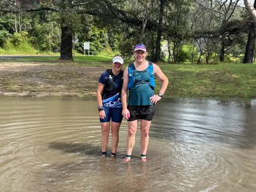 Club members crossing floodwater on a trail