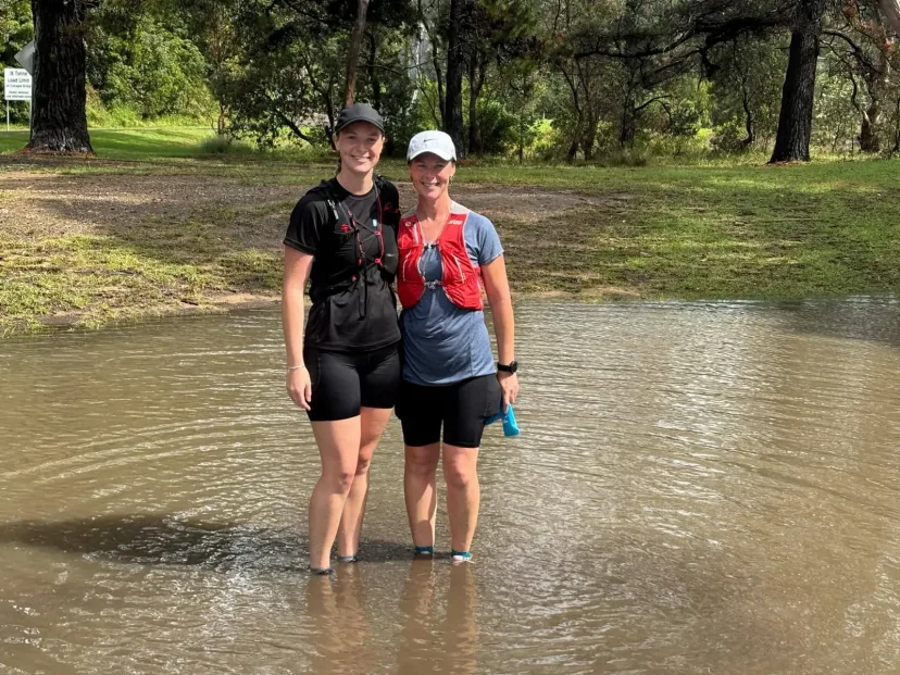 Club members crossing floodwater on a trail